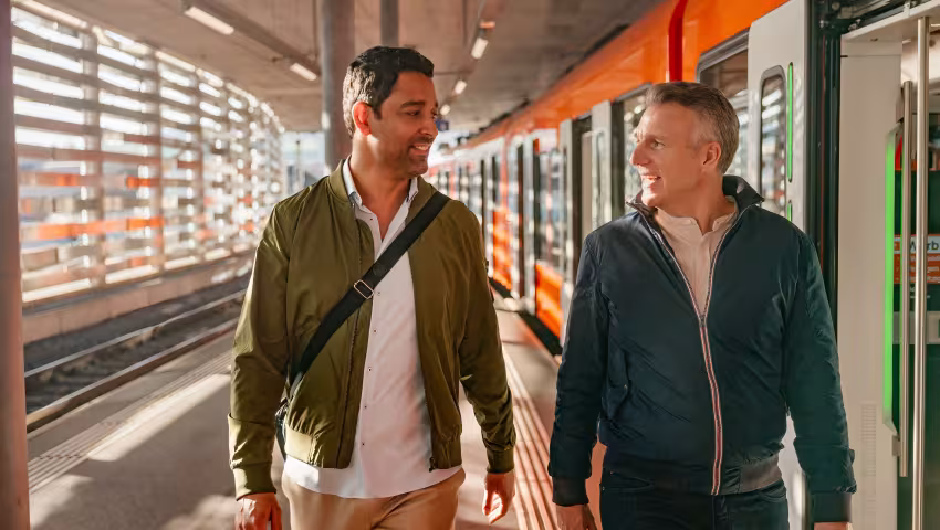 Zwei Personen auf einem Perron in Worb beim Einstieg in einen stehenden Zug.
