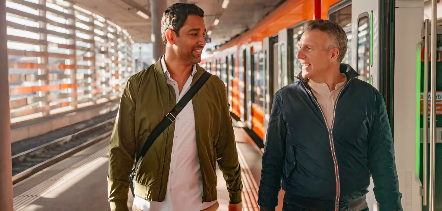 Zwei Personen auf einem Perron in Worb beim Einstieg in einen stehenden Zug.