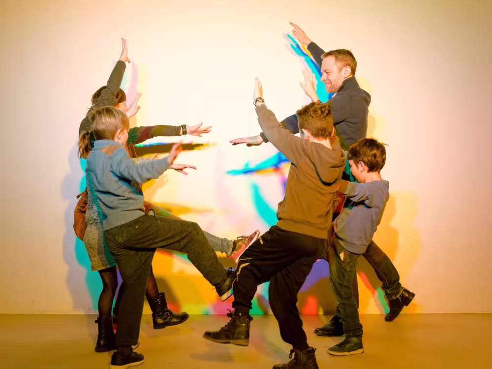 Gruppe von Kindern und Erwachsener spielen vor einer Wand im Sensorium Rüttihubelbad.