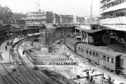1963: Der neue Bahnhof entsteht direkt unter den Gleisen des SBB-Bahnhofs. Zimmerleute erstellen die Schalung für die Betondecke, der Bahnbetrieb läuft nebenbei weiter.