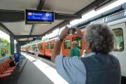 Testperson teste mit dem Fotoapparat den Abfahrtsanzeiger