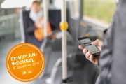 Mann im Bus kontrolliert den Fahrplan auf dem Smartphone, Button mit Fahrplanwechsel, 9.12.18