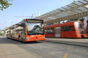 Gelenkbus und Zug am Bahnhof Papiermühle