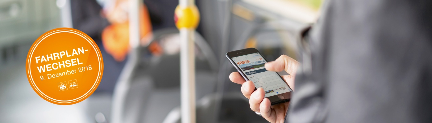 Mann im Bus hält Smartphone in der Hand, Fahrplanwechsel, 9.12.2018