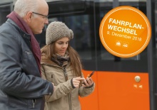 Mann und Frau kontrollieren auf einem Smartphone-Display den Fahrplan, Button mit Fahrplanwechsel, 9.12.18