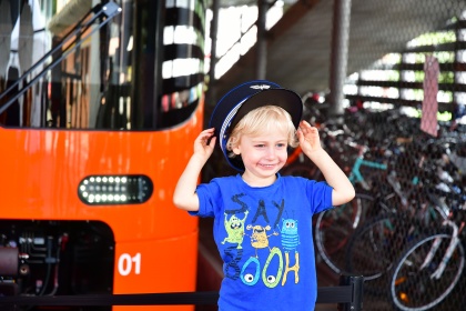 Der neue Worbla Zug, davor ein kleiner Junge mit Eisenbahnermütze. rechts unten steht "Merci!"