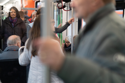 Fahrgast hält sich an Stange im Zug fest